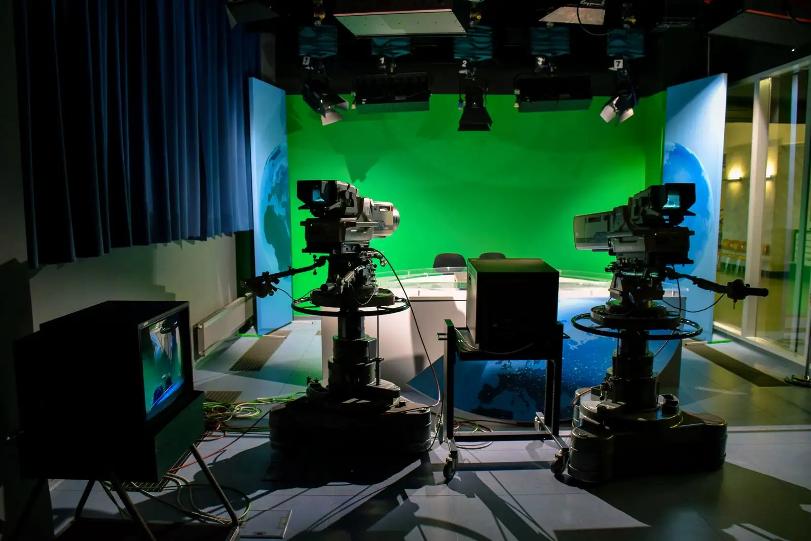 Plateau de télévision d'information avec caméras orientées vers un bureau de présentation éclairé