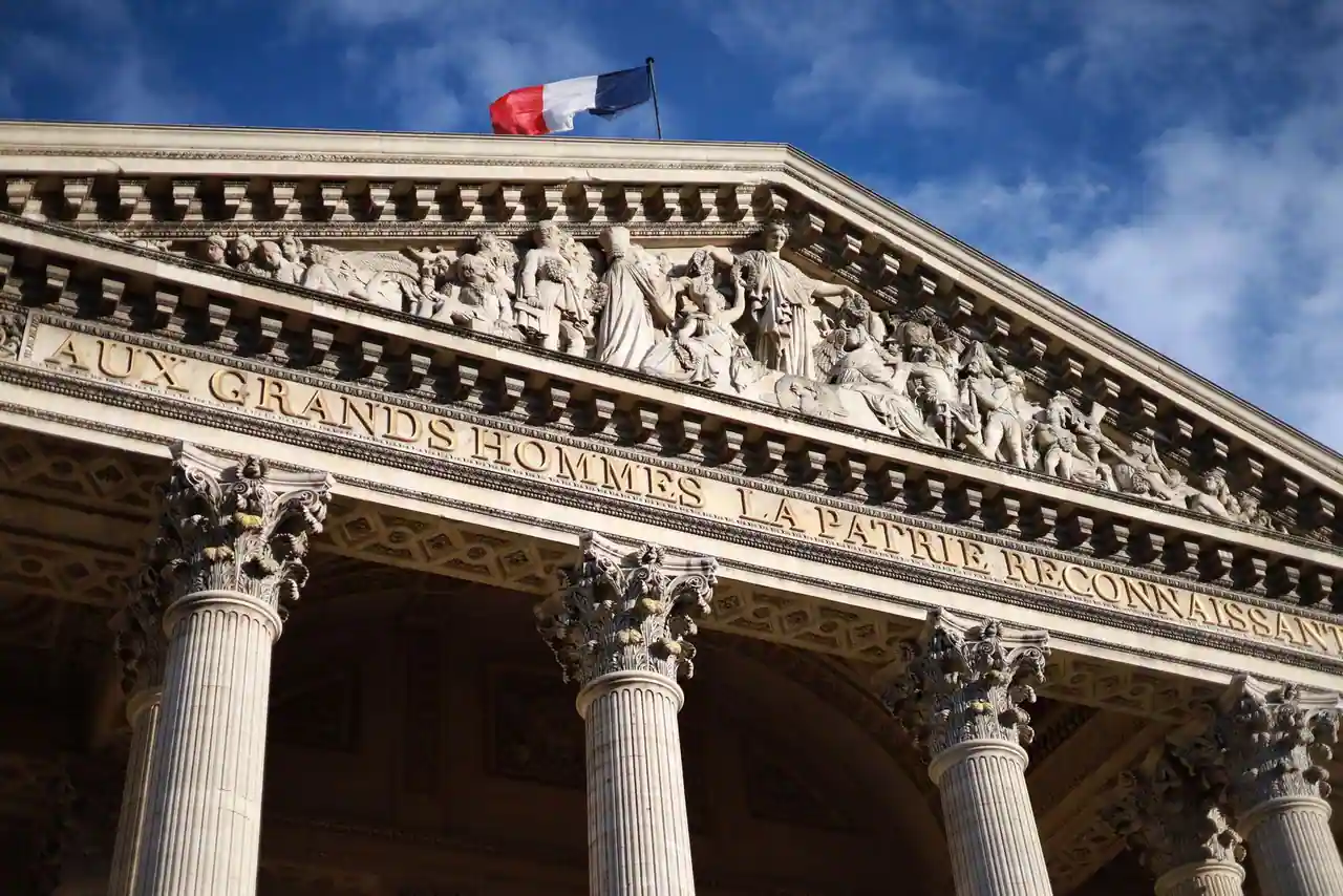 Façade d'un bâtiment institutionnel français orné du drapeau tricolore