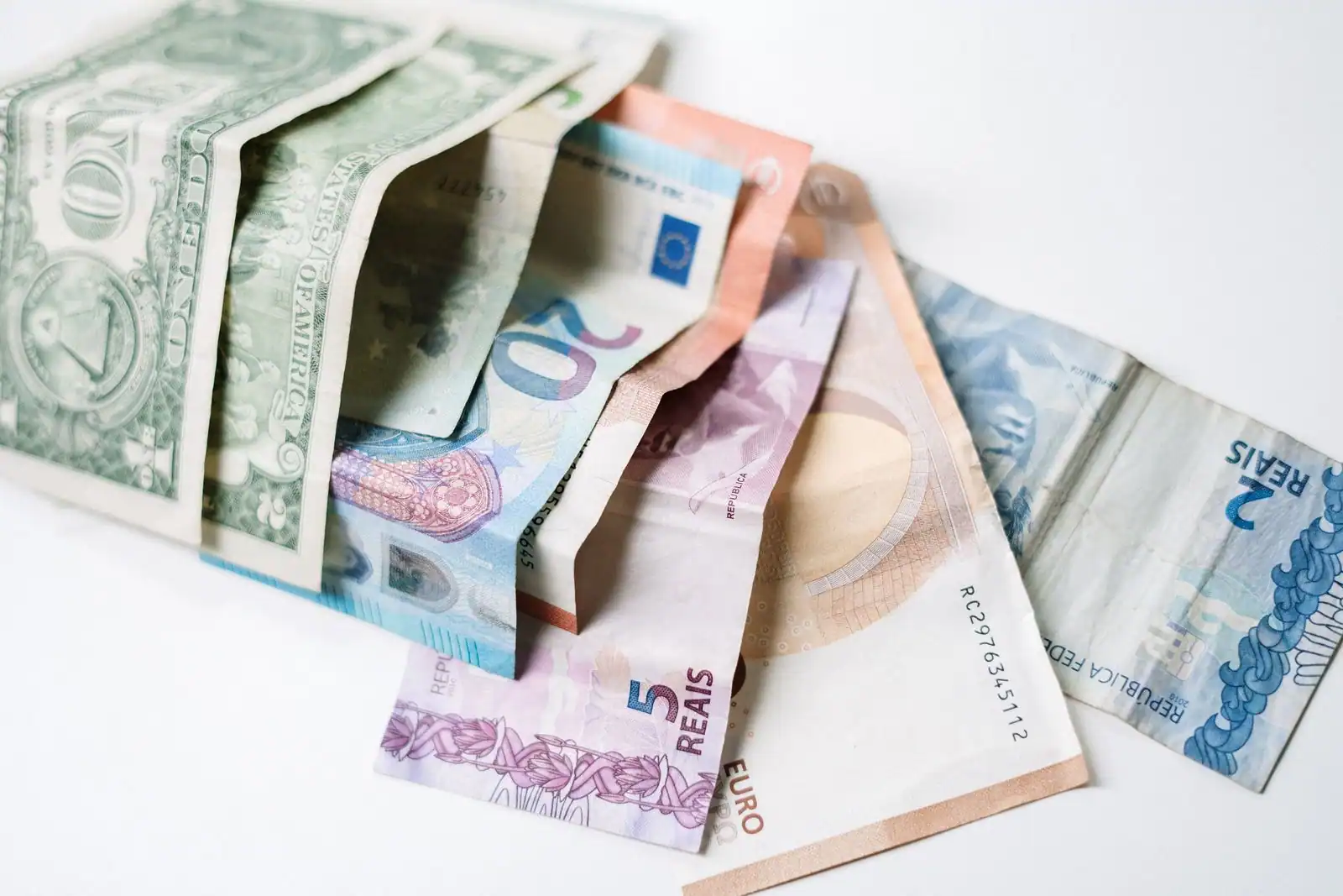 Billets de plusieurs devises, dont des euros et des dollars, posés ensemble, illustrant les taux de change.