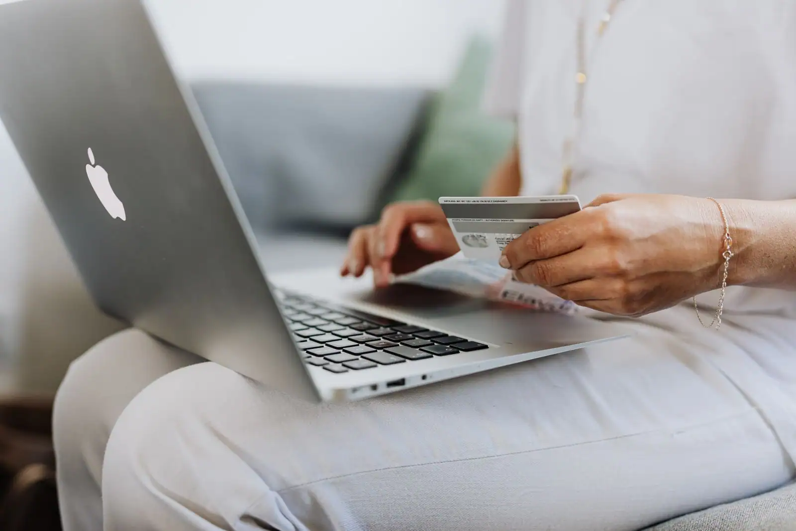 Personne sur un ordinateur portable tenant une carte bancaire pour gérer ses opérations en ligne