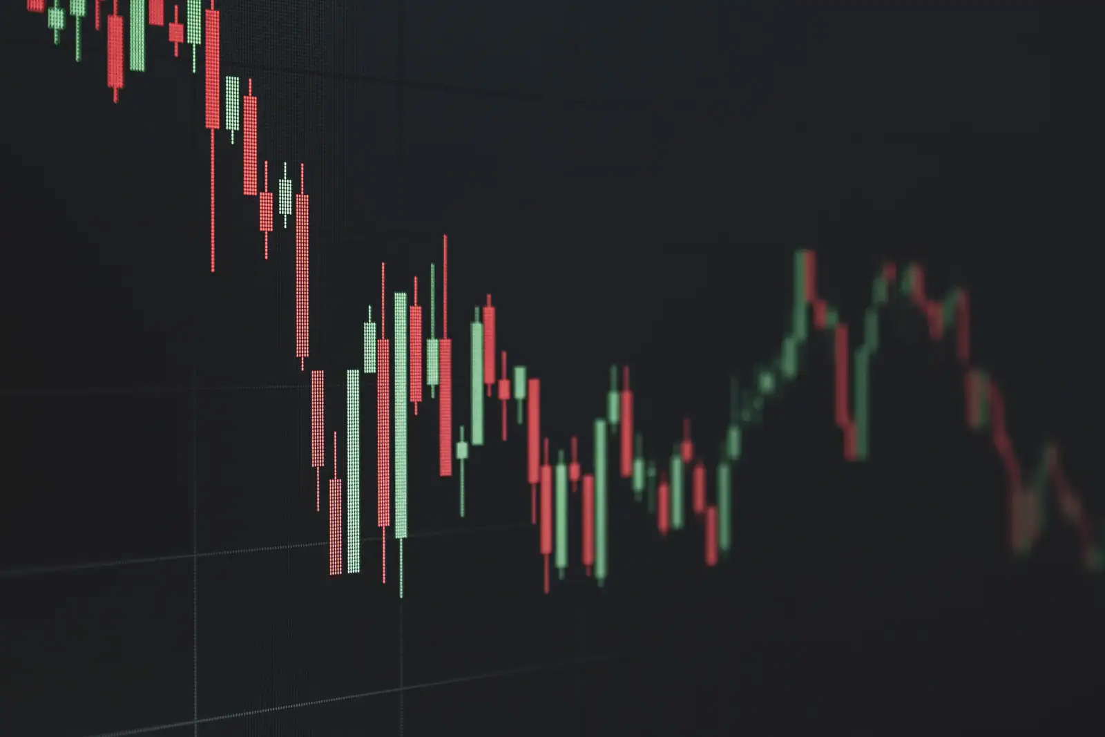 Graphique boursier en chandeliers rouges et verts affiché sur un écran de trading sombre