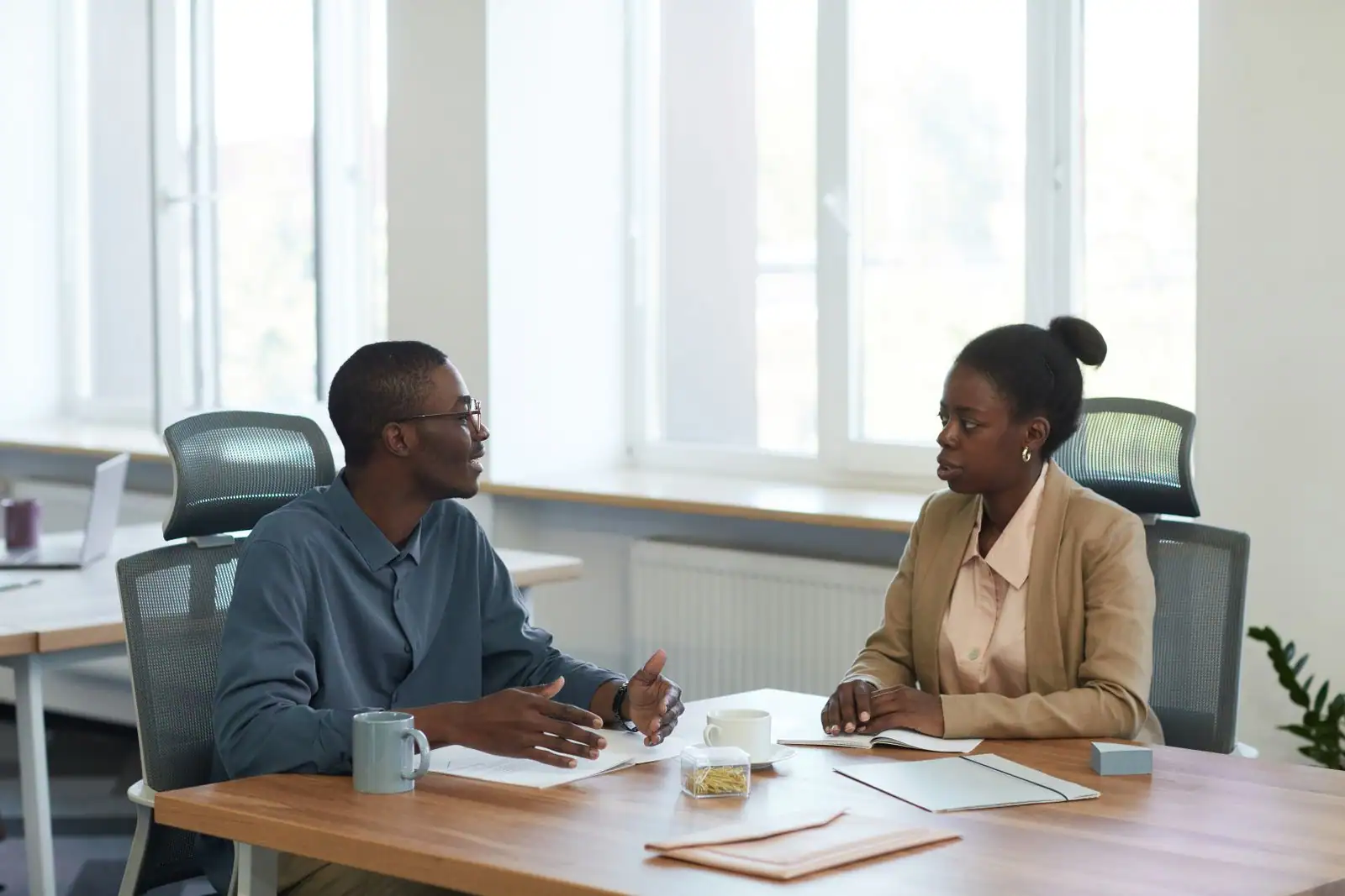 Deux collègues échangeant de façon posée et attentive lors d'une discussion au bureau