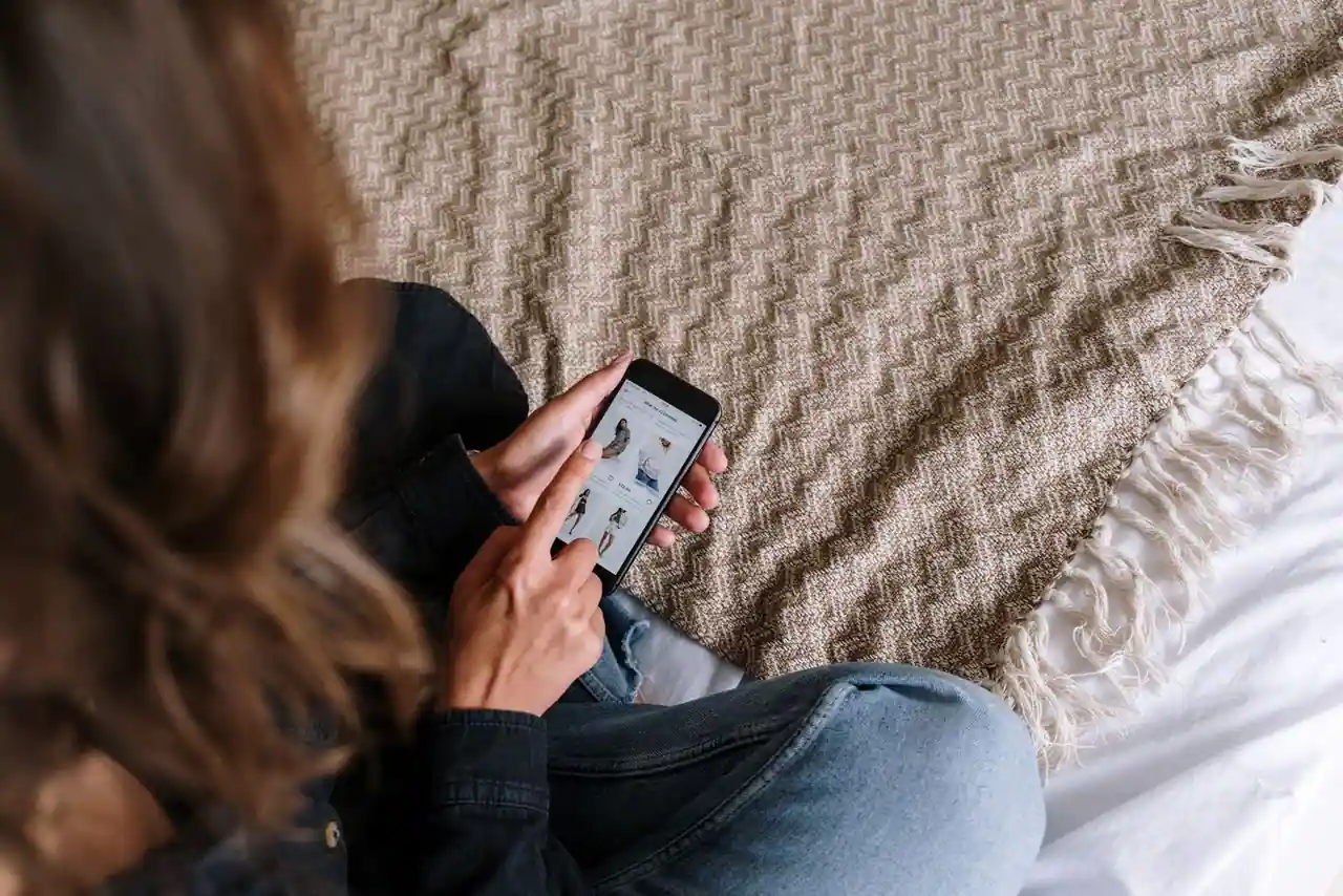 Cliente parcourant une application de mode sur smartphone pour gérer ses achats en ligne