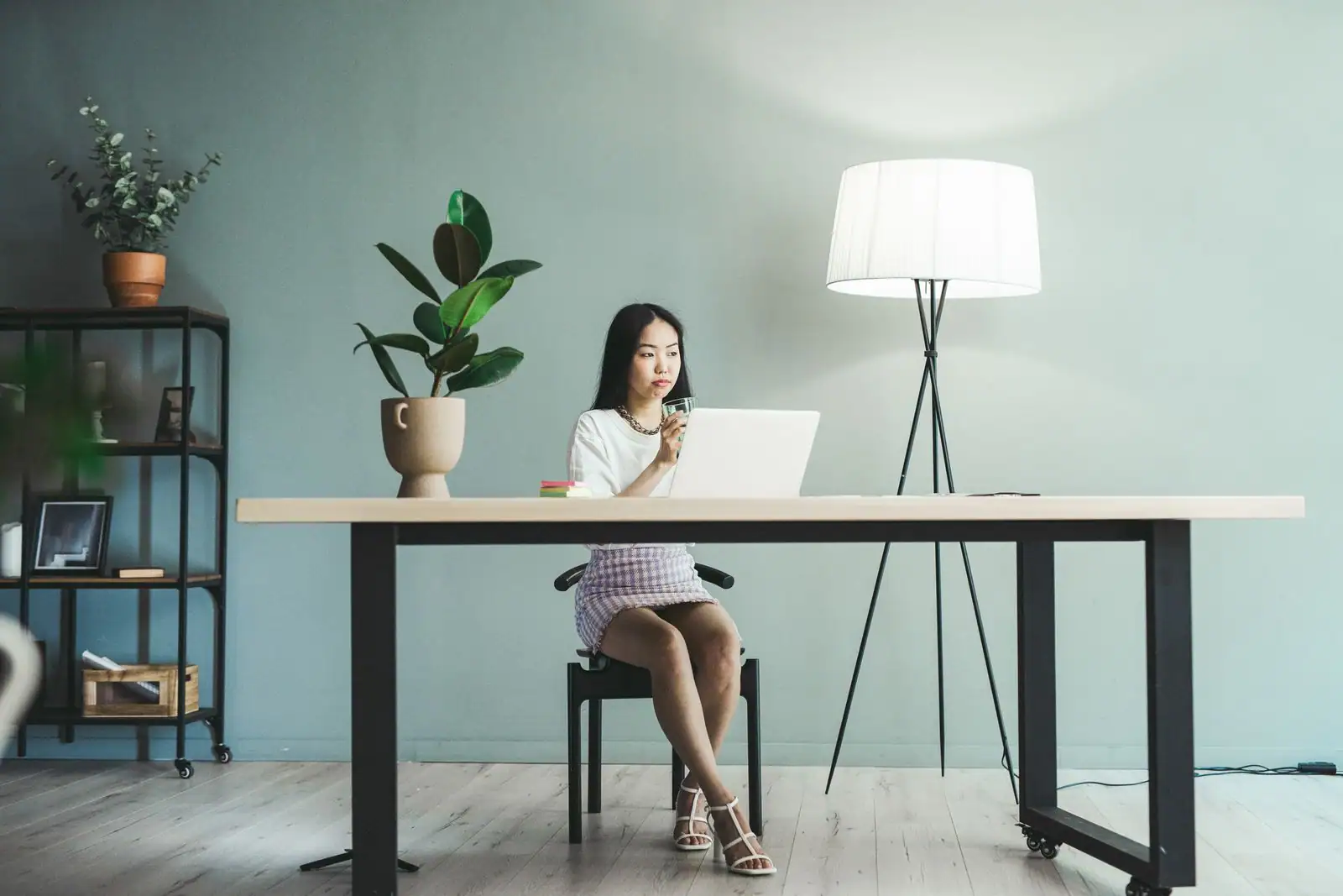 Jeune femme travaillant sur son ordinateur portable à un bureau dans un espace de travail lumineux et épuré