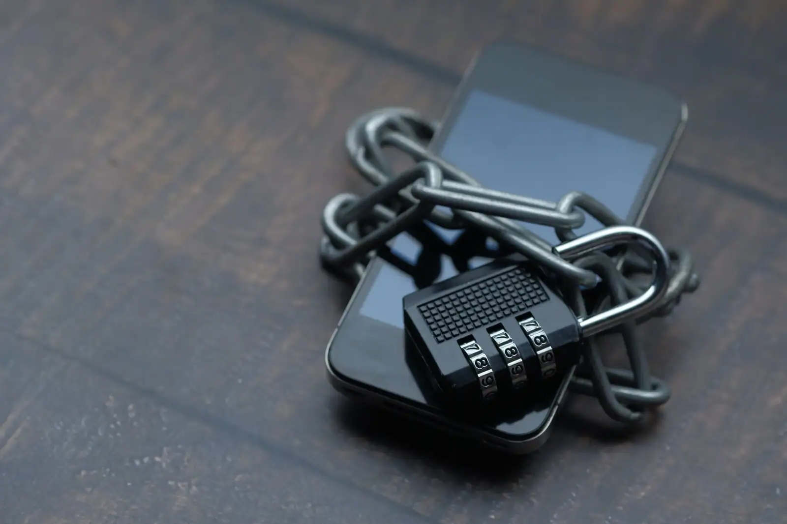 Un smartphone verrouillé par une chaîne et un cadenas à code, illustrant la sécurité des accès numériques