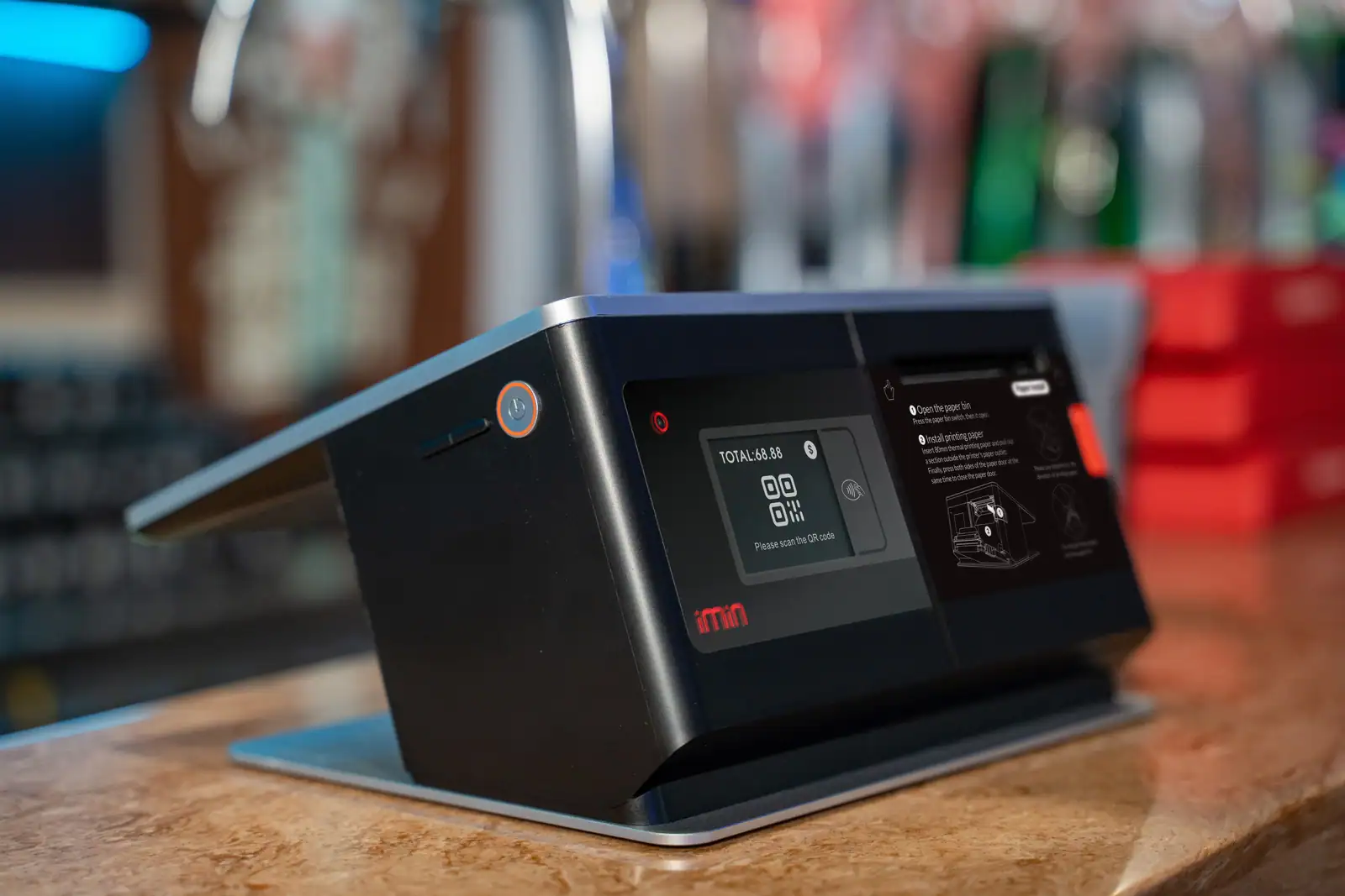 Caisse tactile à écran posée sur le comptoir d'un commerce, affichant le total d'un paiement à régler