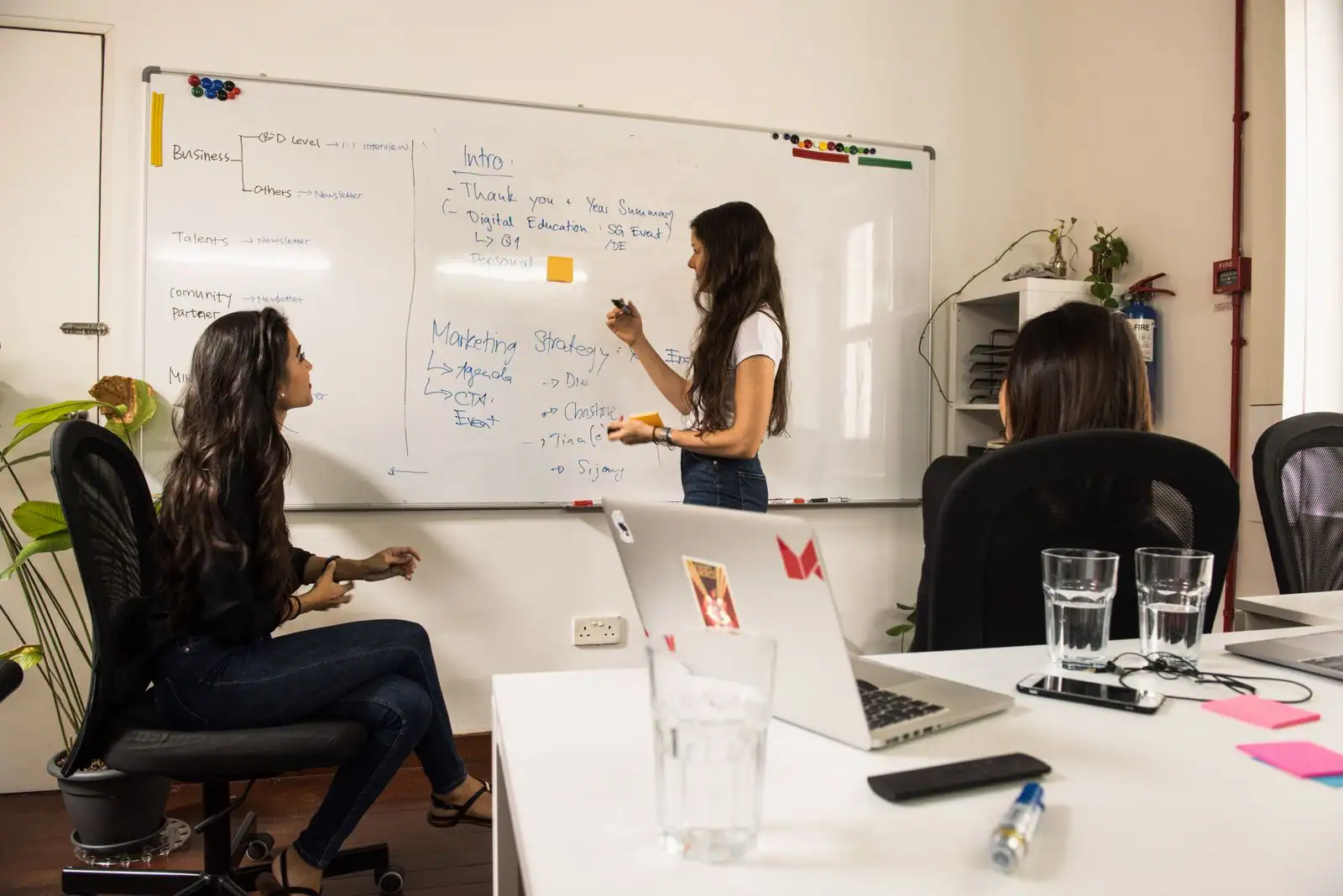 Équipe réunie autour d'un tableau pour planifier les actions de communication d'un projet.
