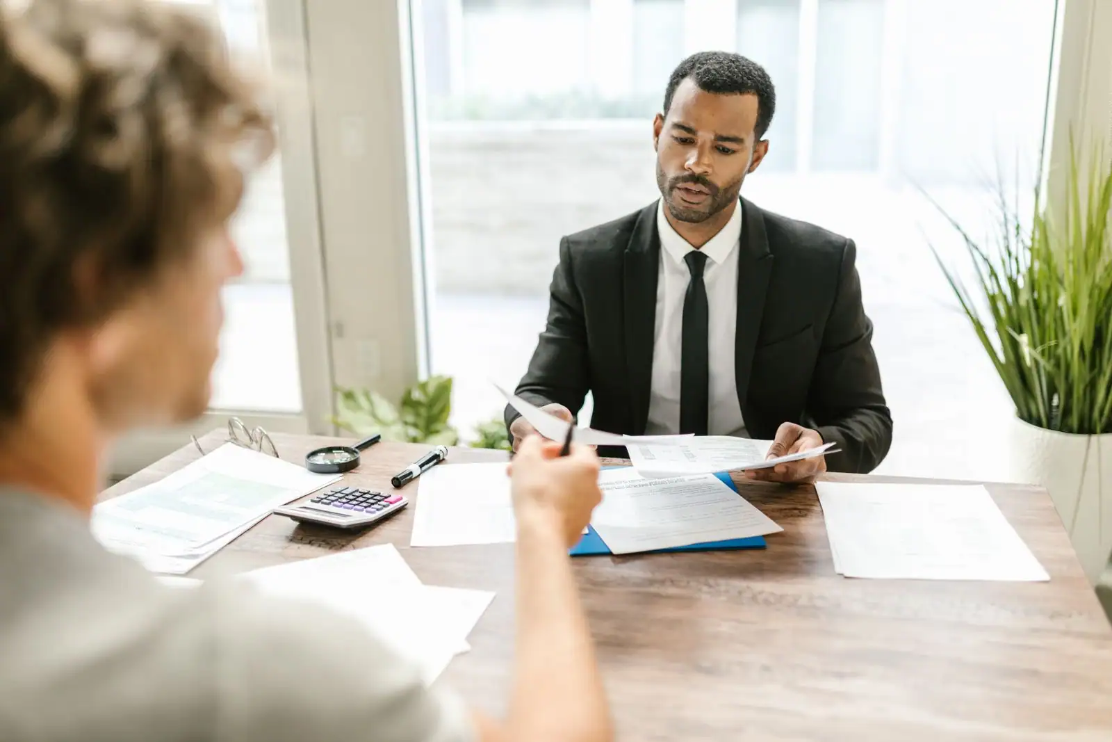 Conseiller examinant un dossier de formation professionnelle au bureau, documents en main