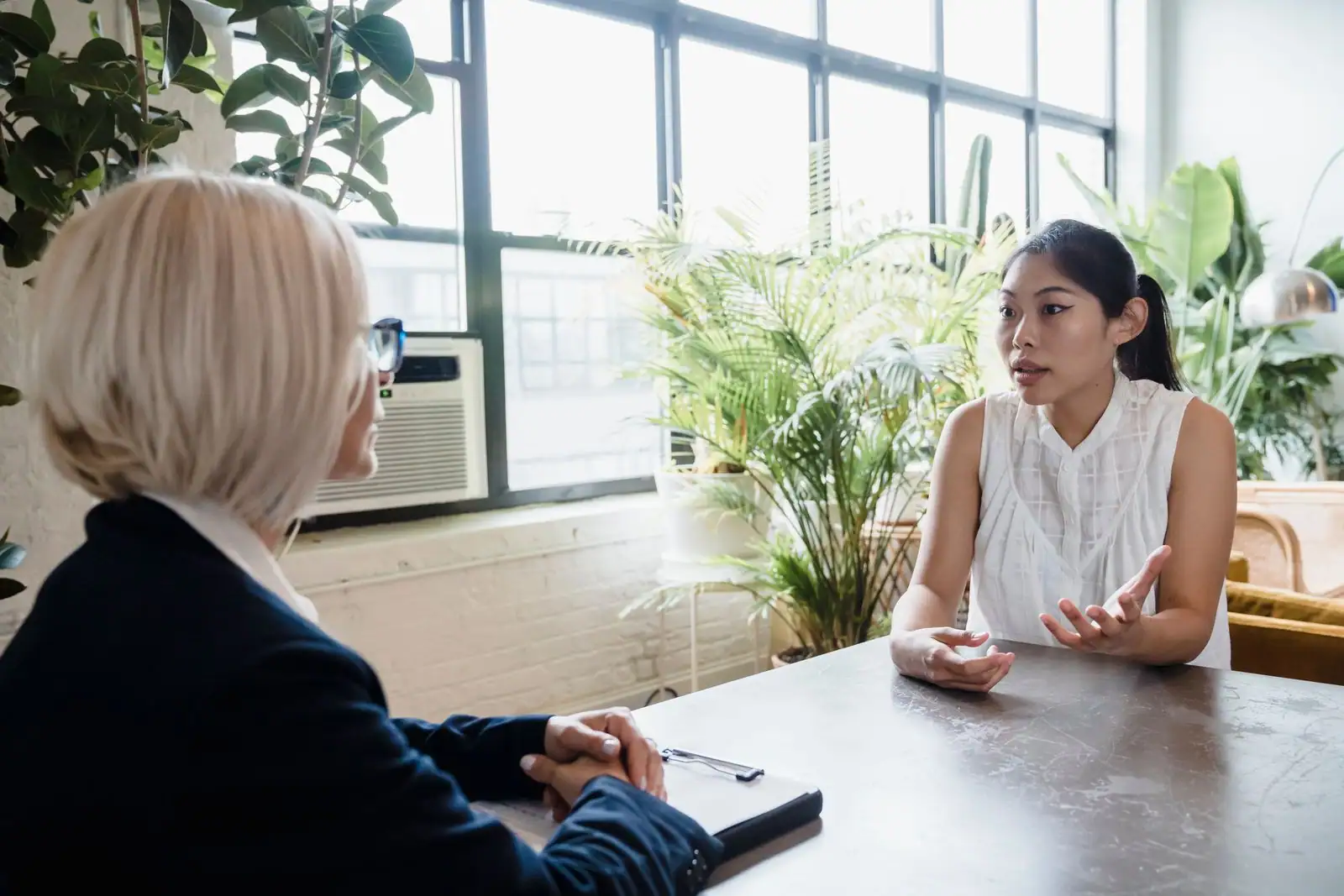 Consultante en bilan de compétences échangeant avec un client dans un bureau professionnel.