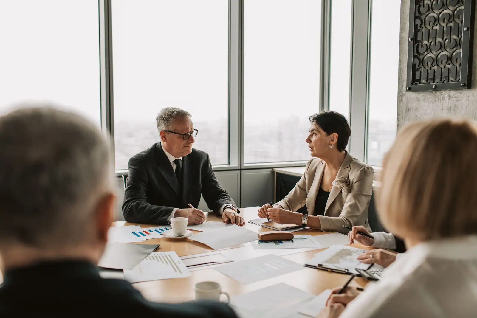 Équipe en réunion de travail autour d'une table, échange sur les priorités du jour.