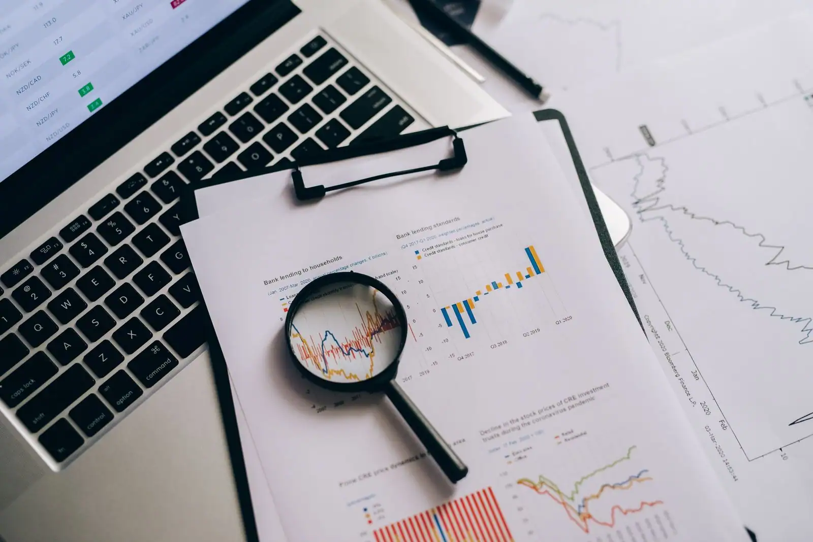 Graphiques économiques et journaux financiers disposés sur un bureau professionnel